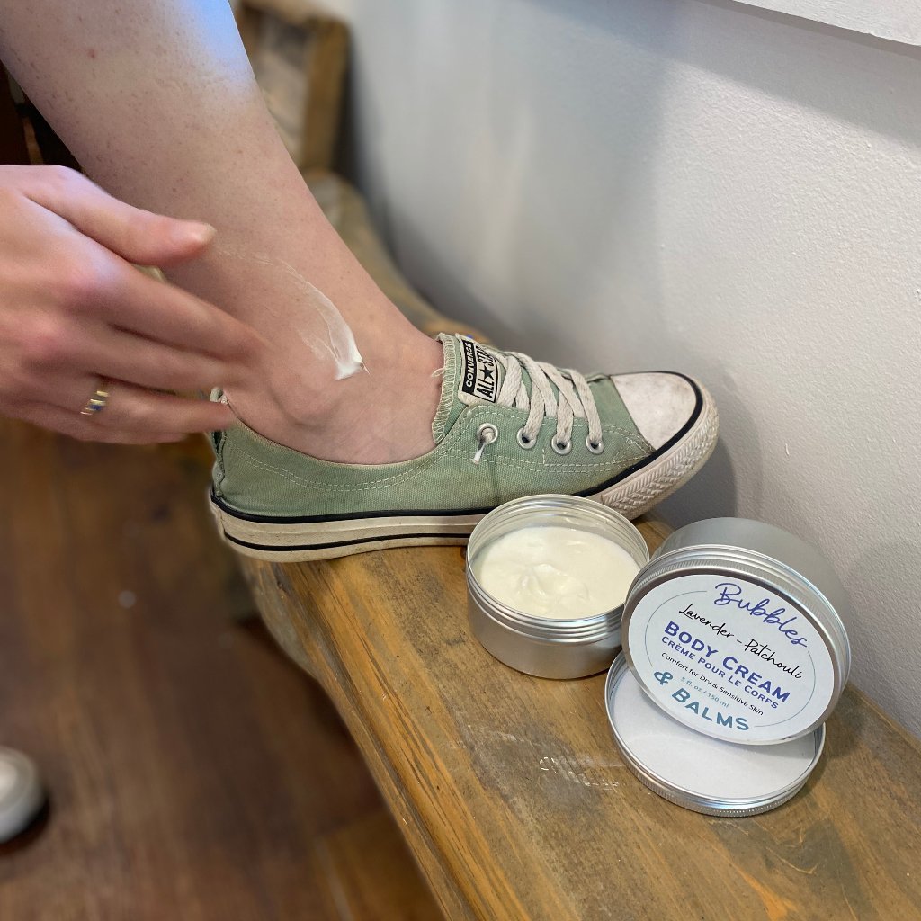 Woman applying Patchouli &amp; Lavender Bubbles &amp; Balms body cream to her dry &amp; sensitive skin.