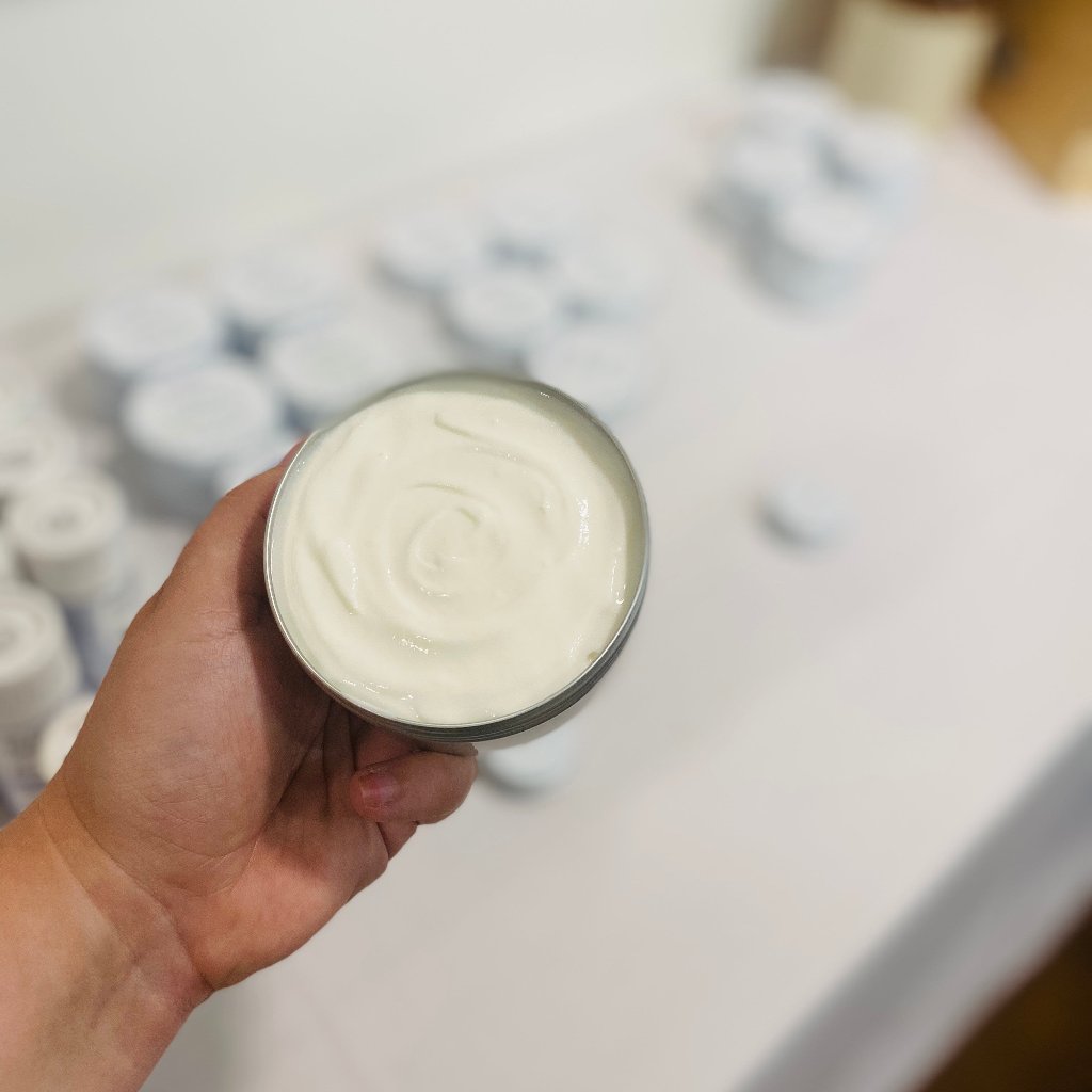 Bubbles &amp; Balms body cream for dry &amp; sensitive skin shown with a pleasant swirl in its plastic-free, aluminum tin.